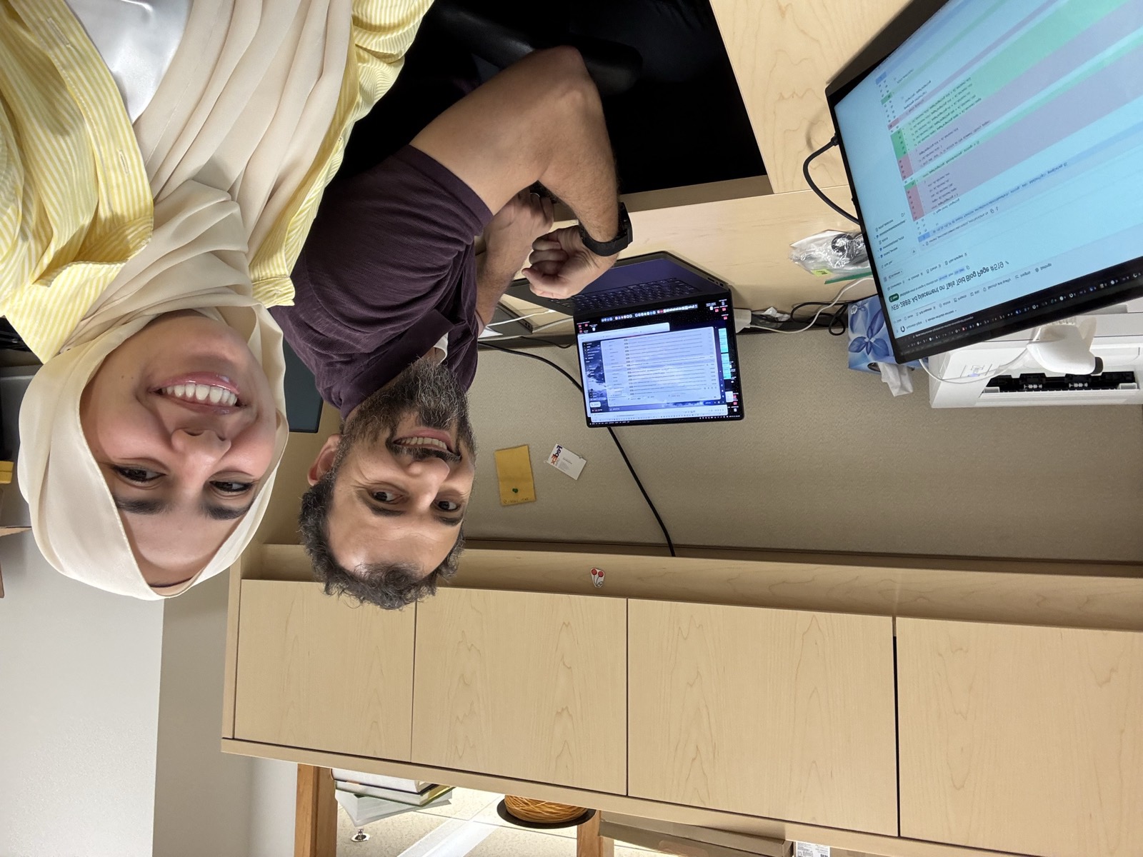 Two lab members at their desks working through data on laptops